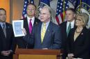 House Budget Committee Chairman Rep. Tom Price, R-Ga., center, holds-up a synopsis of the House Republican budget proposal as he announces the plan on Capitol Hill in Washington, Tuesday, March 17, 2015. The plan includes a boost in defense spending but cuts in the Medicaid program for the poor, food stamps and health care subsidies. (AP Photo/Cliff Owen)