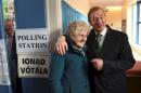 Irish Prime Minister Enda Kenny stands with 88-year-old Bridie McLoughlin in a polling station at St Anthony's School in Castlebar