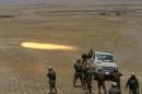 Kurdish Peshmerga forces fire a rocket toward Islamic State militants on the southeast of Mosul