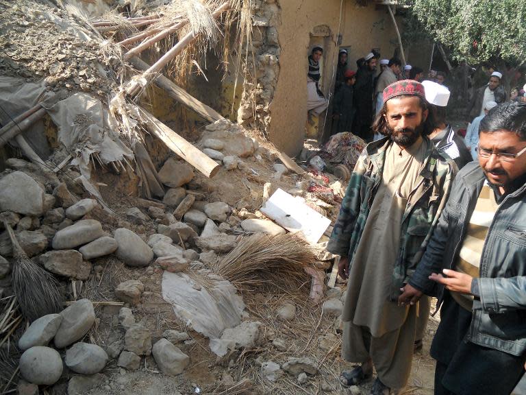 Pakistani Islamic students gather at a destroyed religious seminary belonging to the Haqqani network after US drone strike in Hangu district, Khyber Pakhtunkhwa province, on November 21, 2013