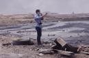 Matt Willingham of PLC stands at the Qayyarah checkpoint, where burning oil still consumes the area. (Photo: Ash Gallagher for Yahoo News)