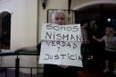A man holds a handwritten message that reads in Spanish; "We are Nisman, Truth and Justice," in front of the building where Sandra Arroyo Salgado, ex-wife of the late Argentina prosecutor Alberto Nisman, held a press conference, in Buenos Aires, Argentina, Thursday, March 5, 2015. Salgado said that experts hired by the family of Argentine prosecutor concluded that he was killed and ruled out the hypothesis of suicide. (AP Photo/Natacha Pisarenko)