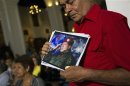A supporter of Venezuelan President Hugo Chavez holds a picture of him, as he attends a mass to pray for Chavez's health in Caracas