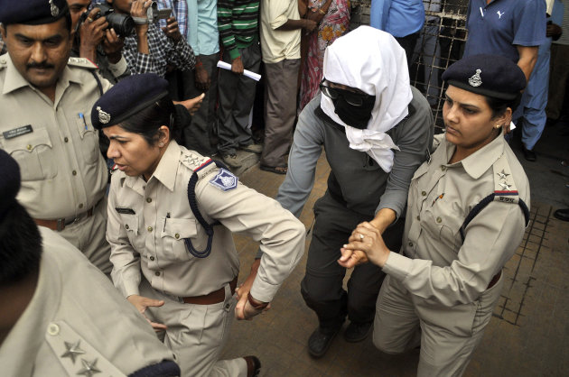 A Swiss woman, center, who, according to police, was gang-raped by a group of eight men while touring by bicycle with her husband, is escorted by policewomen for a medical examination at a hospital in Gwalior, in the central Indian state of Madhya Pradesh, Saturday, March 16, 2013. Thirteen men were detained and questioned in connection with the attack, which occurred Friday night as the couple camped out in a forest after bicycling from the temple town of Orchha, local police officer R.K. Gurjar said. The men beat the couple and gang-raped the woman, he said. They also stole the couple's mobile phone, a laptop computer and 10,000 rupees ($185), Gurjar said. (AP Photo)