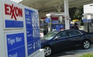 A motorist fills up her car at an Exxon gas station in Arlington, Virginia, August 10, 2011.  REUTERS/Jason Reed
