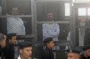 Political activists Ahmed Maher, Ahmed Douma and Mohamed Adel, founder of 6 April movement, look on from behind bars in Abdeen court in Cairo