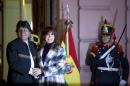 Bolivia's President Evo Morales and Argentina's Cristina Fernandez hold hands as they wait to unveil a bronze statue of Bolivian war of independence heroine Juana Azurduy de Padilla, behind the government house in Buenos Aires, Argentina, Wednesday, July 15, 2015. The statue is a present from Bolivia and replaces a statue of Christopher Columbus brought down in 2013. (AP Photo/Natacha Pisarenko)