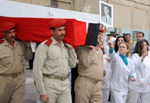 Una enfermera lanza arroz sobre el féretro del sargento Ahmed Ali Husein, muerto en los enfrentamientos, este 12 de mayo de 2011 en el hospital militar Teshrin de Damasco, en una imagen distribuida por la agencia Sana