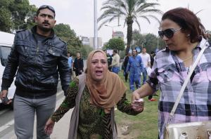An Egyptian woman, center, is escorted out of the site&nbsp;&hellip;