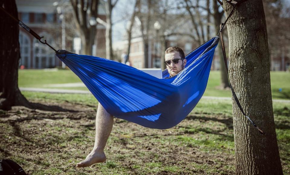 Centre College student Bryce Rowland works on homework in a hammock in front of the Campus Center, Tuesday, April 1, 2014, in Danville, Ky. (AP Photo/...