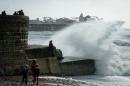 Large waves break against barriers on the seafront in Brighton, southern England on October 27, 2013 as a predicted storm starts to build