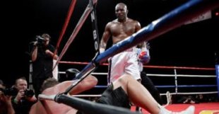 Evander Holyfield of the U.S. stands over Francois Botha of South Africa after knocking down Botha in the eighth round of their heavyweight bout at the Thomas &#38; Mack Center in Las Vegas - 0