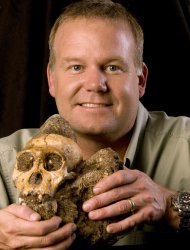 This image released by the journal Science shows Lee R. Berger of the University of Witwatersrand in South Africa holding the cranium of Australopithecus sediba. A detailed analysis of 2 million-year-old bones found in South Africa offers the most powerful case so far in identifying the transitional figure that came before modern humans, findings some are calling a potential game-changer in understanding evolution. [AP Photo/Courtesy of Lee Berger and the University of Witwatersrand)