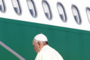 Pope Francis boards a plane at Rome's Fiumicino international airport, Monday, July 22, 2013. It's wheels up on Pope Francis' first trip abroad as pontiff. A special Alitalia flight carrying Francis, his entourage and journalists who will cover him on his week-long visit to Brazil took off 10 minutes behind schedule Monday from Rome's Leonardo da Vinci airport. Keeping to his example that the Catholic church must be humble, Francis carried his own black hand luggage. He even kept holding it with his left hand while he used his left to shake hands with some of the VIPs who turned out to wish him well and while he climbed the stairs to the jet's entrance. Among the dignitaries was Italian Premier Enrico Letta. (AP Photo/Riccardo De Luca)