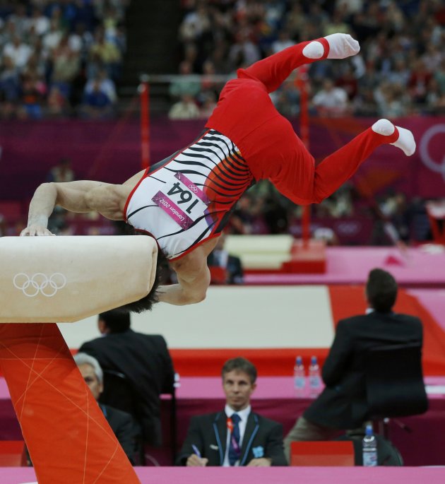 A judge watches as Kohei Uchimura of Japan falls off the pommel horse during the men's gymnastics team finalat the London 2012 Olympic Games