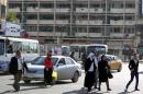 Iraqis cross a street in central Baghdad on December 1, 2013