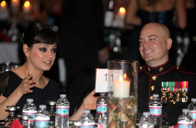 Sgt. Scott Moore and his guest, actress Mila Kunis stand during the National Anthem at the 236th Marine Corps birthday ball for 3rd Battalion, 2nd Marine Regiment, 2nd Marine Division in Greenville, N.C., on Friday Nov. 18, 2011. (AP Photo/Marine Corps., Cpl. Johnny Merkley)