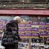 A woman walks past a closed-down travel agency plastered with concert posters in Madrid Monday May 21, 2012.  Spain's economy minister de Guindos said the Spanish economy, which has contracted by 0.3 percent in each of the past two quarters, will shrink by about the same amount in the second quarter of 2012. The forecast is for it to decline 1.7 percent for the year. Unemployment stands at a staggering 24.4 percent, and exceeds 50 percent for people under age 25.(AP Photo/Paul White)