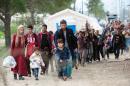 Migrants and refugees cross the Greek-Macedonian border near Gevgelija, on October 19, 2015