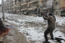 A rebel fighter aims his weapon as he stands amidst snow during clashes with Syrian pro-government forces in the Salaheddin neighbourhood of Aleppo on December 11, 2013