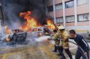 Firefighters try to extinguish the fire on vehicles set ablaze by protesters in Chilpancingo, Guerrero State, Mexico on November 12, 2014