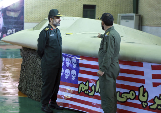 FILE - This photo released on Thursday, Dec. 8, 2011 by the Iranian Revolutionary Guards, claims to show the chief of the aerospace division of Iran's Revolutionary Guards, Gen. Amir Ali Hajizadeh, left, listening to an unidentified colonel pointing to a U.S. RQ-170 Sentinel drone which Tehran says its forces downed. Hajizadeh warned that Iran will target U.S. bases in the region in the event of war with Israel, raising the prospect of a broader conflict that would force other countries to get involved, Iranian state television reported Sunday, Sept. 23, 2012. (AP Photo/Sepahnews, File) THE ASSOCIATED PRESS HAS NO WAY OF INDEPENDENTLY VERIFYING THE CONTENT, LOCATION OR DATE OF THIS IMAGE