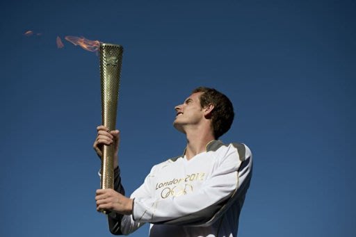 Andy Murray carries the Olympic torch in Centre Court at the Olympic tennis venue