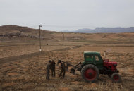 FILE - In this Tuesday, April 17, 2011 file photo, men check a plow and tractor in a field along the highway near the southern city of Kaesong, south of Pyongyang, North Korea. The United States sent a plane loaded with a small but symbolic shipment of emergency aid that was due to arrive in flood-stricken North Korea on Saturday, Sept. 3, in the latest sign of a thaw in relations between the countries. (AP Photo/David Guttenfelder, File)