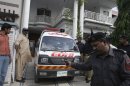 An ambulance removes dead bodies of shooting victims from a house in Lahore, Pakistan on Monday, April 30, 2012. The widow and mother-in-law of one of two Pakistanis men shot and killed by a CIA contractor last year, have been murdered in Lahore, police said. It appears the killings may have been related to the large amount of 