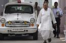 India's Samajwadi Party chief Yadav walks next to his official government car at his residence in Lucknow