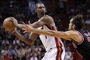 Miami Heat's Chris Bosh looks to pass around Chicago Bulls' Joakim Noah during their NBA basketball game in Miami, Florida