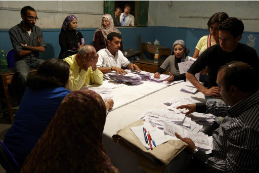 Egyptian election workers count the ballots following the end of the two day presidential election in Cairo, Egypt, Thursday, May 24, 2012. As vote-counting began, exit polls by several Arab television stations suggested the Brotherhood's Mohammed Morsi was ahead of the pack of 13 candidates. The reliability of the various exit surveys was not known, and a few hours after the end of two days of voting, only a tiny percentage of the ballots had been counted. (AP Photo/Fredrik Persson)