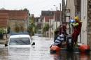 Rescuers evacuate residents onto a dinghy through a flooded street on June 1, 2016 in Souppes-sur-Loing, southeast of Paris