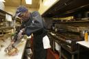 In this Friday, June 6, 2014 photo, executive chef Raymond Nicholson cuts a corned beef reuben sandwich at Corky & Lenny's Restaurant & Deli in Woodmere Village, Ohio. The Commerce Department releases first-quarter gross domestic product on Wednesday, June 25, 2014. (AP Photo/Tony Dejak)