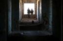 Rebel fighters stand in a damaged building in Quneitra countryside