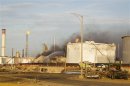 Firefighters work at extinguishing flames from fuel storage tanks at Amuay oil refinery in Punto Fijo
