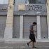 Man walks outside of closed Piraeus bank branch in central Athens