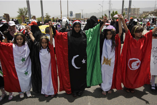Yemeni girls wear dresses in the colors of many nations, with from left: Syria, Yemen, pre-Gadhafi Libya, Egypt and Turkish flags at a demonstration by anti-government protestors demanding the resignation of Yemen's President Ali Abdullah Saleh in Sanaa, Yemen, Friday Aug. 26, 2011.(AP Photo/Hani Mohammed)