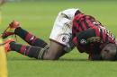AC Milan's forward Mario Balotelli, lays on the turf after he injured himself in a collision during a round of 16th Champions League soccer match between AC Milan and Atletico Madrid at the San Siro stadium in Milan, Italy, Wednesday, Feb. 19, 2014. (AP Photo/Emilio Andreoli)