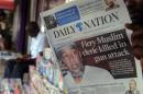Picture taken on April 2, 2014 in Nairobi shows a man holding the Kenyan newspaper 'Daily Nation' with a headline about prominent radical Muslim cleric Abubaker Shariff Ahmed who was gunned down north of the port city of Mombasa
