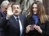 French President and UMP candidate Nicolas Sarkozy and his wife Carla Bruni-Sarkozy leave after casting their votes in the first round of French presidential elections in Paris, France, Sunday, April 22, 2012.  (AP Photo/Michel Euler)