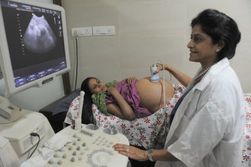 Dr. Nayna Patel (right) conducts a scan on 30-year-old surrogate mother Rinku Macwan in Anand on October 31, 2011