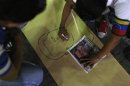 A man draws an image depicting the late Venezuelan President Hugo Chavez during a gathering in support of President-elect Nicolas Maduro, at Plaza Bolivar in Caracas
