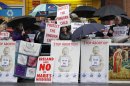 Protesters opposed to abortion hold placards outside the Marie Stopes clinic in Belfast, Northern Ireland, Thursday, 18, 2012. The first abortion clinic on the island of Ireland has opened in Belfast, sparking protests by Christian conservatives from both the Catholic and Protestant sides of Northern Ireland's divide. The Marie Stopes center plans to offer the abortion pill to women less than nine weeks pregnant _ but only if doctors determine they're at risk of death or long-term health damage from their pregnancy. That's the law in both Northern Ireland and the Republic of Ireland, where abortion is otherwise illegal. (AP Photo/Peter Morrison)