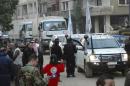 A United Nations and Syrian Arab Red Crescent aid convoy is seen along a street in Homs city