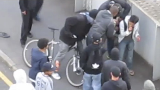 In this image from amateur video, a gang of youths in Barking, East London surround Malaysian accountancy student  Mohammed Asyraf Haziq, 20, who had been attacked and mugged in the street by an earlier group during rioting Monday Aug. 8 2011.  As one of this group appeared to help Haziq to his feet others took the opportunity to open his backpack and remove other valuables. The video of the attack on Haziq went viral Tuesday Aug 9 and has become one of the most memorable scenes from four days of unrest. So shocking was the robbing of an injured man that Prime Minister David Cameron felt moved to describe it as a sign of a deeper societal malaise in Britain. (AP Photo/Abdul Hamid via Sky/ APTN) UK OUT TV OUT NO SALES