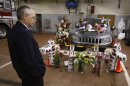 Bryan Bayer, Vice President of the West Webster Firefighters Association, looks at a memorial placed at a car inside the main fire hall, dedicated to two volunteer firefighters who were shot on Christmas Eve, in West Webster, New York