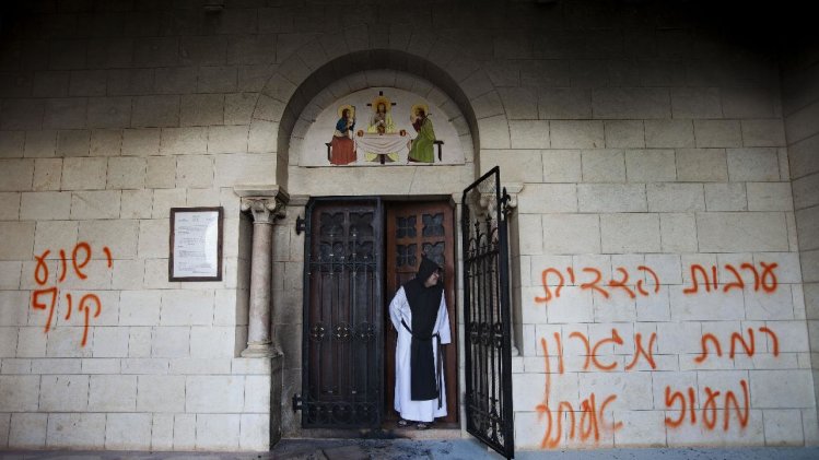 A catholic monk stands in a doorway of the Latr