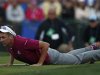 Team Europe golfer Poulter lays on the ground to line up a putt on the 18th green during the afternoon four-ball round at the 39th Ryder Cup golf matches at the Medinah Country Club