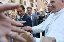 Pope Francis shakes hands with pilgrims as he leaves Castel Gandolfo's central square on August 15, 2013